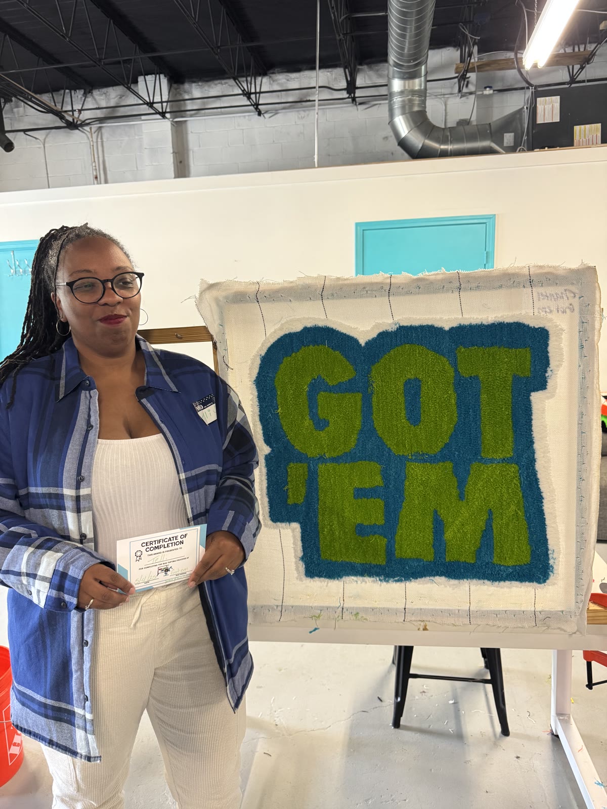 Workshop customer with 'GOT 'EM' tufted piece
