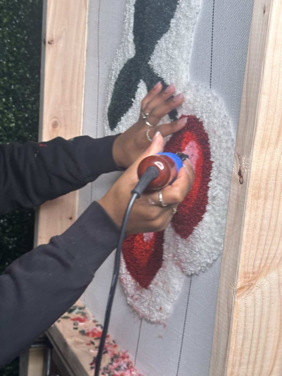 Close-up of hands using the tufting gun